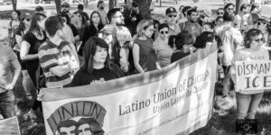 Several people standing holding a sign that says "Latino Union of Chicago"